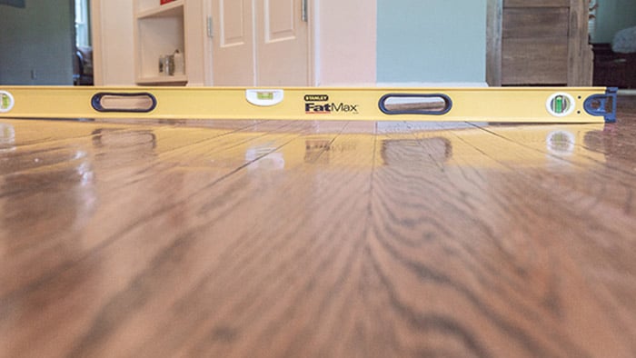 View of a level spanning a depression in a residential home's wooden floor